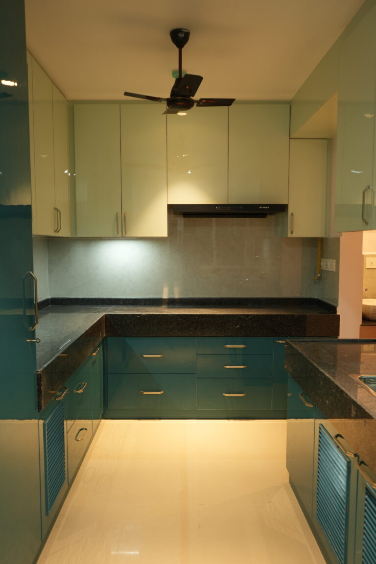 Semi-modular kitchen with teal cabinets and granite counter