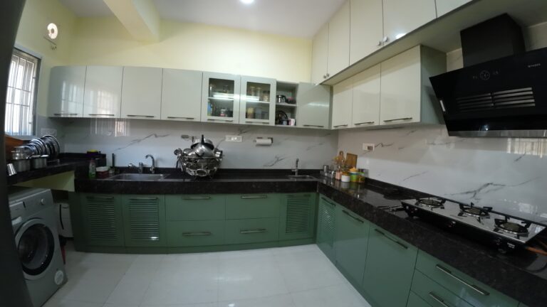 Modular kitchen with green base cabinets and white wall units